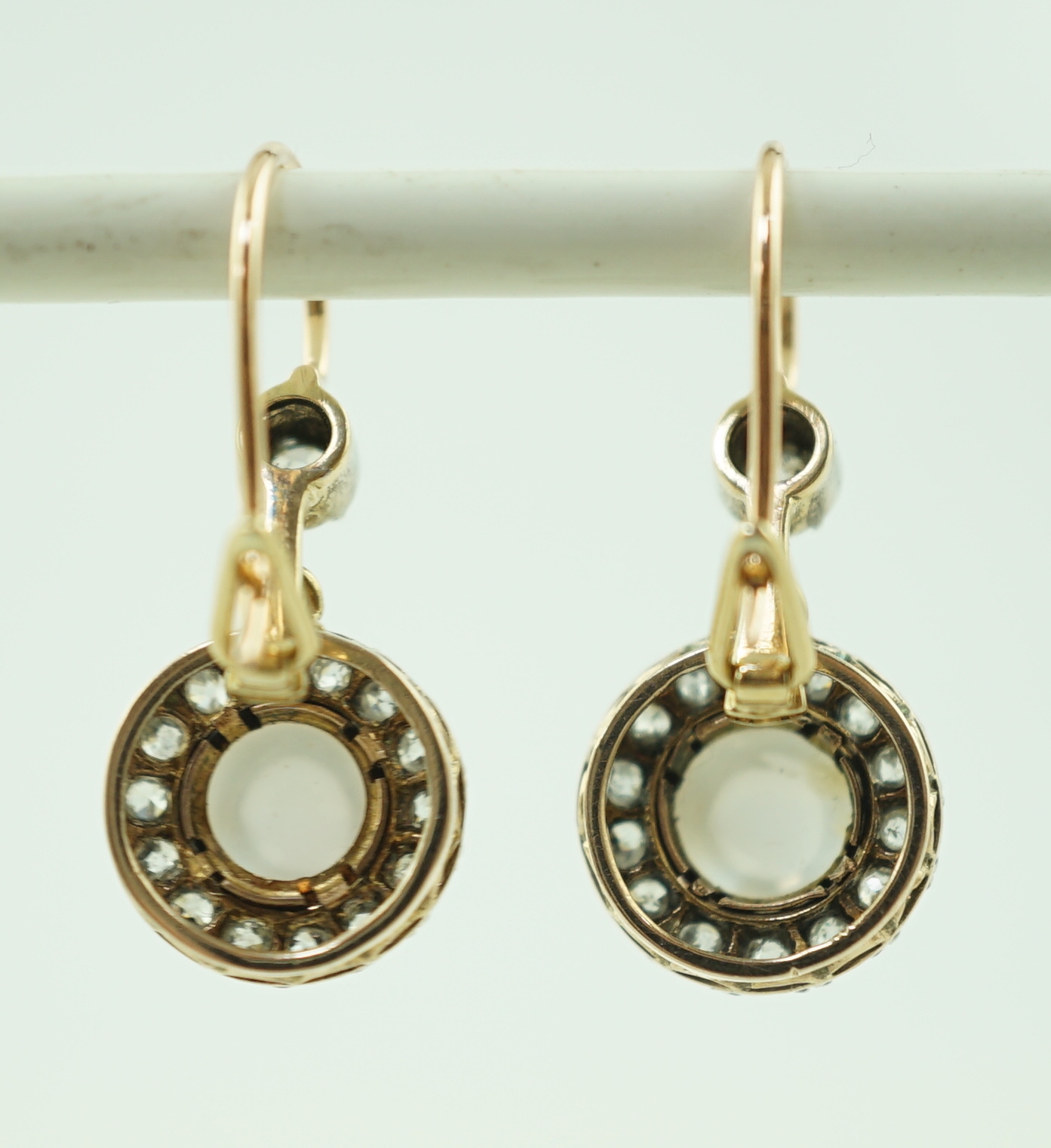 A pair of early 20th century gold, moonstone and old round cut diamond set cluster drop earrings